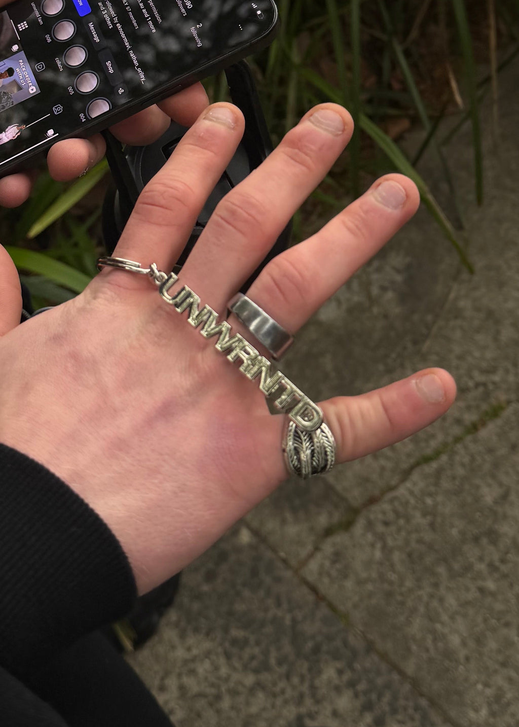 Detail of the raised UNWRNTD lettering on the chrome keychain