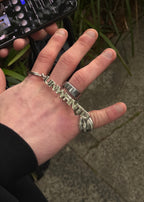 Detail of the raised UNWRNTD lettering on the chrome keychain